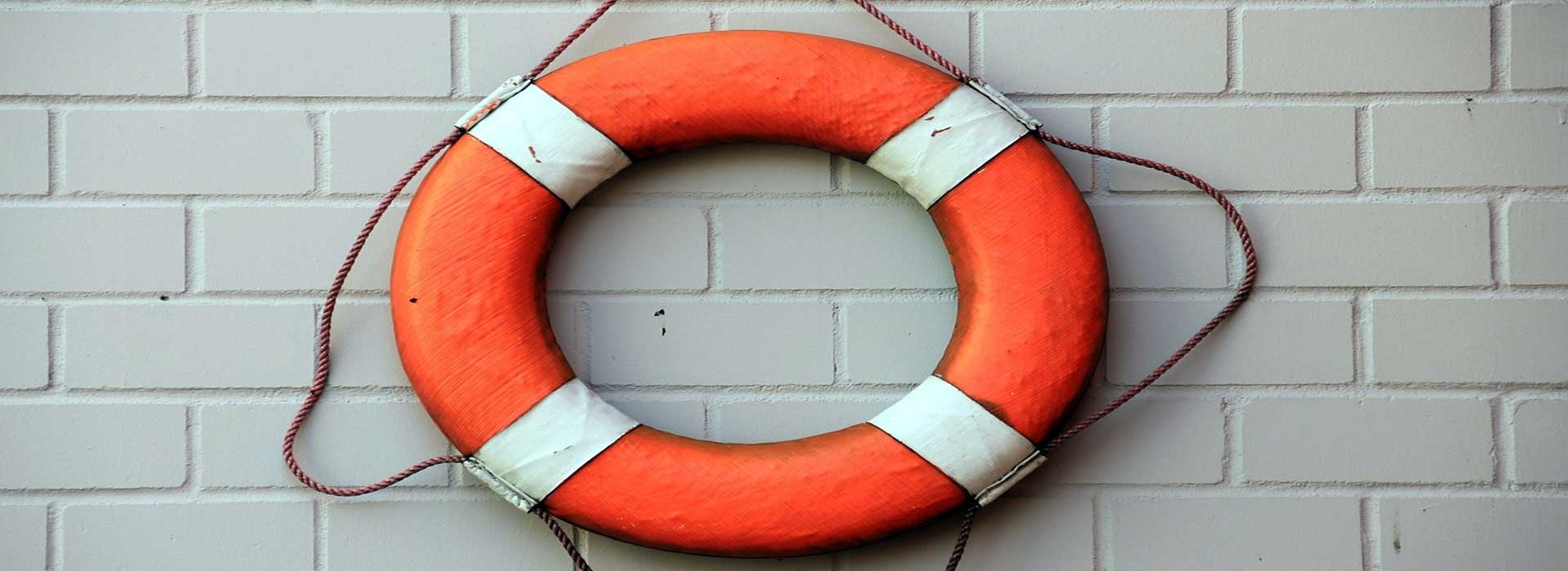 brick wall witjh life bouy hanging up with rescue rope